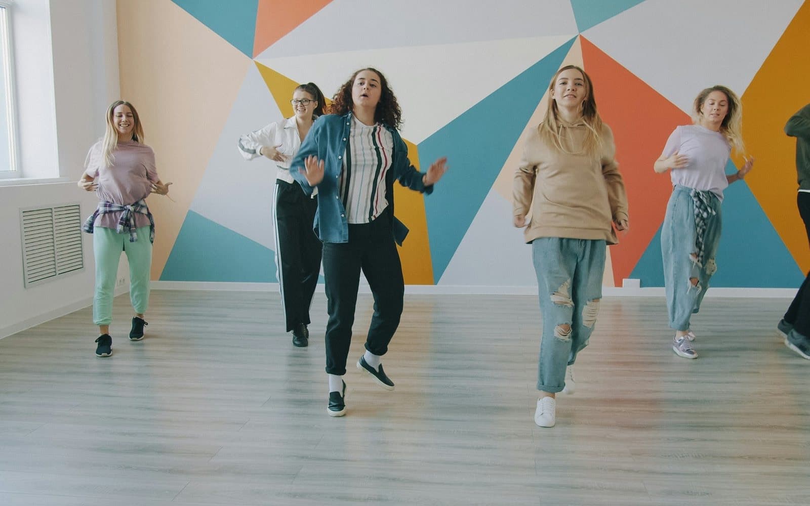 Teenagers and young adults dancing together in a studio
